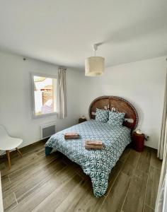 una camera da letto con un letto con un piumone blu e una finestra di Maison 300m de l’océan, 4 a 6 personnes a Mimizan