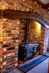 uma cozinha de tijolos com um fogão numa parede de tijolos em Forget me not cottage em Ironbridge