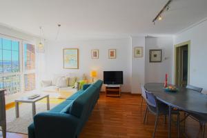 uma sala de estar com um sofá e uma mesa em El Rincón del Puerto em Santander
