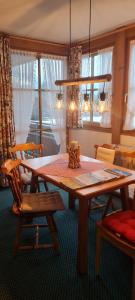 uma sala de jantar com uma mesa de madeira e cadeiras em Landhaus Eibelesee em Oberstaufen