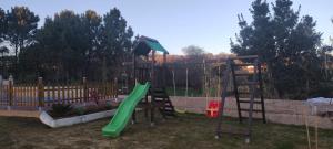 einen Spielplatz mit einer grünen Rutsche und einer Leiter in der Unterkunft Apartamentos Os Cerros in Portonovo