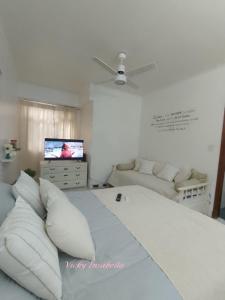 1 dormitorio blanco con 1 cama grande y TV de pantalla plana en Excelente ambiente pleno centro en Mar del Plata