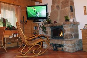 a living room with a stone fireplace with a television at Chata Góralska Aggeusz in Wisła +30 photos