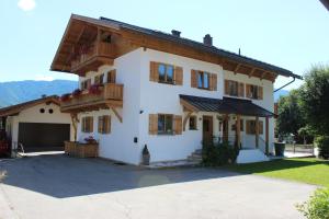 een groot wit huis met een garage bij Ferienwohnungen Bürger in Reit im Winkl