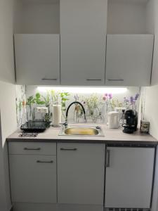 a kitchen with white cabinets and a sink at Ferienwohnungen Fritze Bürger in Schiefling am See