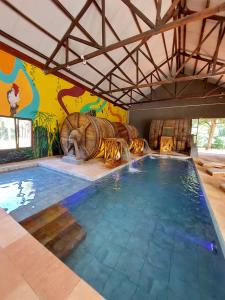a large swimming pool with a room with a wine barrel wall at Momora distrito selva in Santa Ana