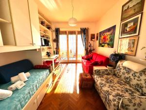 een woonkamer met een bank en een rode stoel bij Suite Fronte Mare - Sanremo in Sanremo