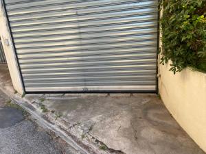 una porta del garage di metallo sul lato di una casa di Superbe Appartement vue mer Pointe Croisette a Cannes