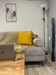 ein Wohnzimmer mit einem Sofa mit einem Laptop und einem Glas Wein in der Unterkunft Raise Averof Serviced Apartments in Athen