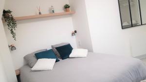 a bedroom with a bed with two pillows on it at Les Jardins de la quiétude in Bettancourt-la-Ferrée