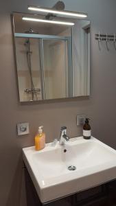 a bathroom with a white sink and a mirror at B & B Vandenbroucke Joseline in Ieper