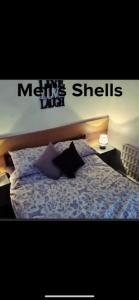 a bedroom with a bed with a sign that says memphis shells at Mells Shells in Hemsby