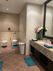 La salle de bains est pourvue de 2 lavabos, de toilettes et d'un miroir. dans l'établissement Luxury 1BR apartment in Anantara Hotel Palm Jumeirah connected Anantara Hotel, à Dubaï