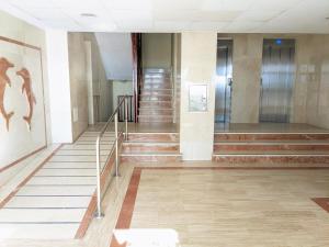 a hallway of a building with stairs and a painting at Apartamento en la playa con garaje in Cádiz