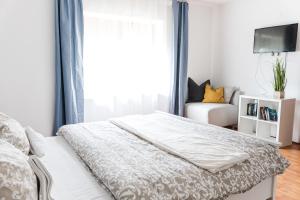 a white bedroom with a bed and a window at Tulipános Ház in Badacsonytomaj