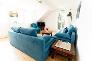 una sala de estar con 2 sofás azules y una mesa. en Villa Schwertführer en Velden am Wörthersee