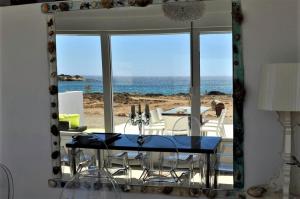 una sala da pranzo con specchio e vista sull'oceano di Sofia Villas Pounta Beach ad Afiartis