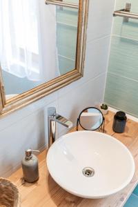 ein Badezimmer mit einem weißen Waschbecken und einem Spiegel in der Unterkunft Tulipános Ház in Badacsonytomaj