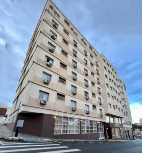 a tall building on a street with a crosswalk at Hotel Uirapuru in Araraquara