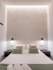 sypialnia z dużym białym łóżkiem z 2 poduszkami w obiekcie Loft Retiro w Madrycie