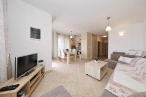 a living room with a couch and a flat screen tv at Apartments Punta in Privlaka