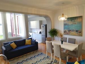 ポルトにあるLusitania Garden Apartment - Jardim Privadoのリビングルーム(青いソファ、テーブル付)