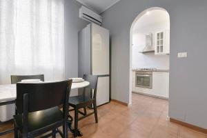uma sala de jantar com mesa e cadeiras e uma cozinha em Nettuno 5 stelle- Appartamento elegante con suite em Bolonha