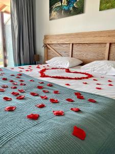 - un lit avec des pétales de rose rouge dans l'établissement Hotel Carre Noir, à Porto-Vecchio