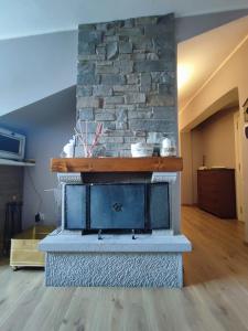 Una chimenea de piedra en una habitación con una pared de piedra. en Mansarda Shabby Chic, en Fiumalbo