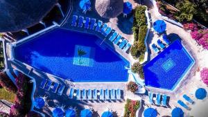 an overhead view of a swimming pool with blue umbrellas at Spectacular Hadas Sunset and Ocean view in Manzanillo