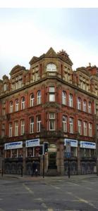 un grande edificio in mattoni rossi all'angolo di una strada di 2 bedroom city centre apartment 35 Victoria street a Liverpool
