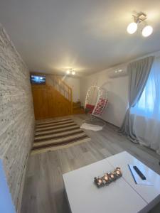 a living room with a staircase and a table at Escapadă la munte in Malaia in Malaia