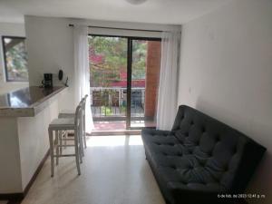 a living room with a couch and a kitchen with a window at Hotel Torre Primavera in Medellín