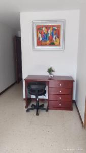 a desk with a chair and a painting on a wall at Hotel Torre Primavera in Medellín