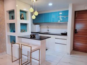 a kitchen with a counter and some blue cabinets at Gangothri in Trivandrum
