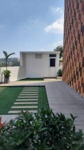 un patio con un edificio y un patio de césped en Gangothri en Thiruvananthapuram
