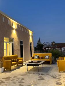 a patio with yellow couches and a coffee table at مزرعه فلج المعلا in Falaj al Mu‘allá