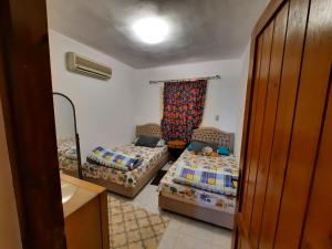 - une petite chambre avec 2 lits et une fenêtre dans l'établissement Stella Di Mare - Amazing Two Bedrooms Sea View Chalet - Families only, à Ain Sokhna