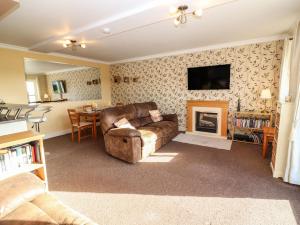 uma sala de estar com um sofá e uma lareira em Seaforth em Kilkee