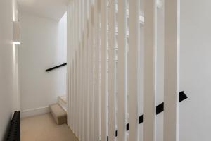 a hallway with a white and black striped wall at The Mews at St Swithins Place in Bath