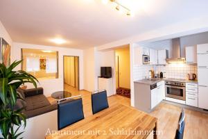 eine Küche und ein Wohnzimmer mit einem Tisch und Stühlen in der Unterkunft Astoria Apartments in Schruns-Tschagguns