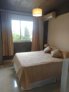 Un dormitorio con una cama grande y una ventana en Jujuy 303 en San Miguel de Tucumán