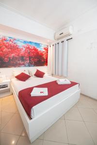 um quarto com uma grande cama branca com um quadro na parede em Expo Hotel em São Paulo