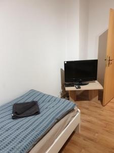 a bedroom with a bed and a desk with a television at FeWo Nina 2 - Monteurwohnung in Weißenfels