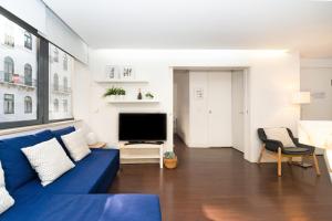 リスボンにあるComfortable Apartment in Marquês de Pombalのリビングルーム(青いソファ、テレビ付)