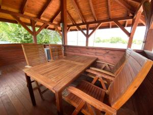 drewniany stół i 2 krzesła na ganku w obiekcie Domek z prywatną plażą w mieście Radzyń