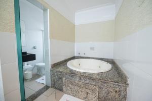 a bathroom with a bath tub and a toilet at Expo Hotel in Sao Paulo