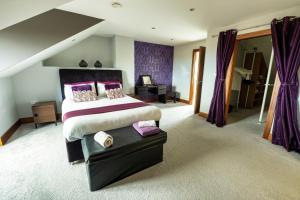 エニスクロンにあるHouse By The Sea & Golf Courseのベッドルーム1室(紫色のカーテンが付いた大型ベッド1台付)