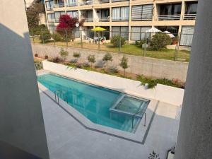 an overhead view of a swimming pool in front of a building at Hermoso y acogedor departamento a pasos del mar - Ideal Parejas, Teletrabajo in Concón