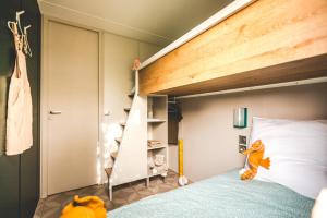 ein Schlafzimmer mit einem Etagenbett mit einer Leiter in der Unterkunft Chalet Teifëlslee in Goebelsmuhle